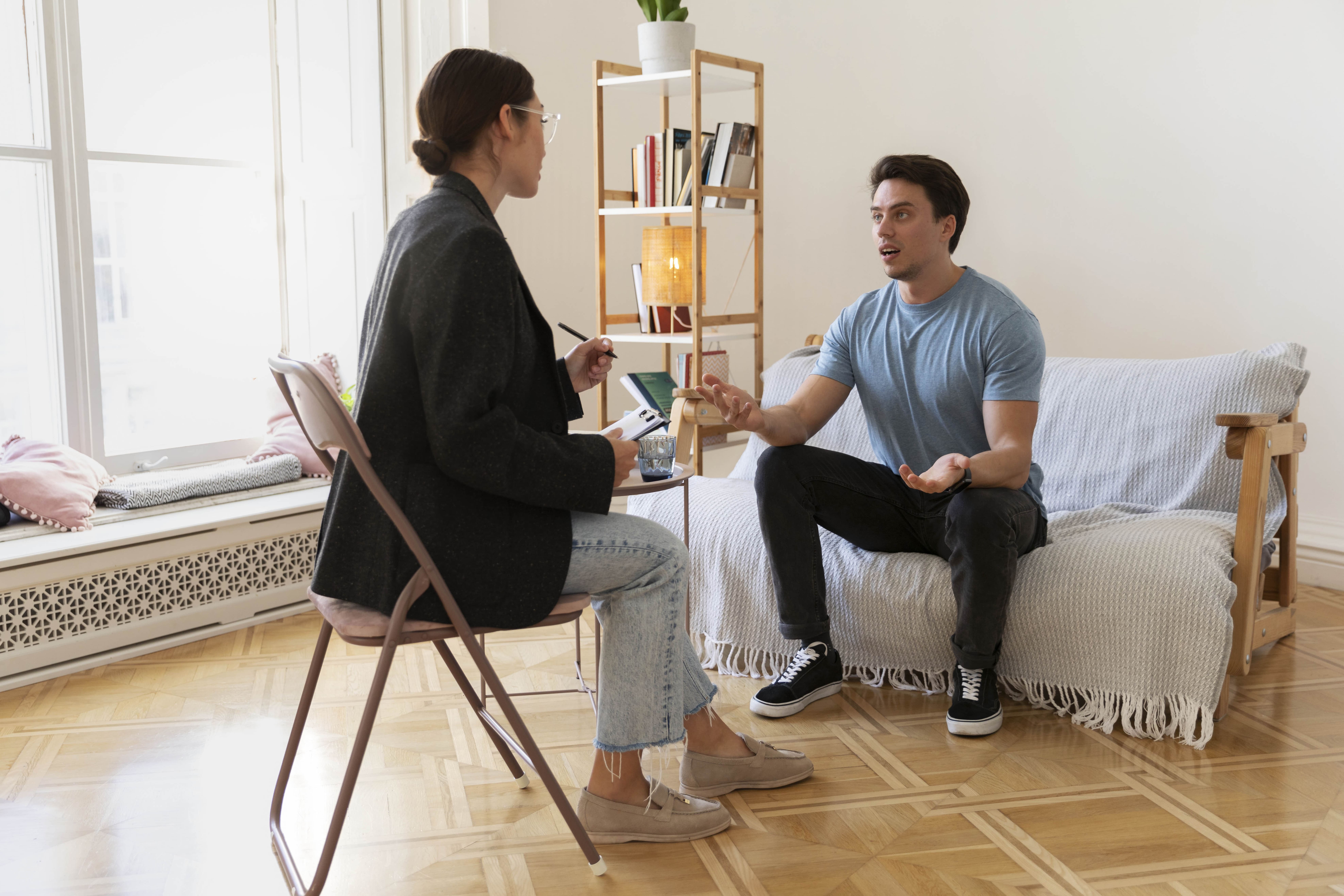 Client and coach talking in a calm, plant-filled room